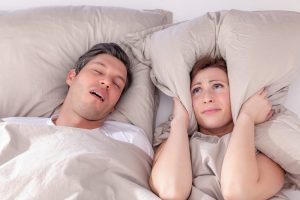 Snoring man and young woman. Couple sleeping in bed stock photo