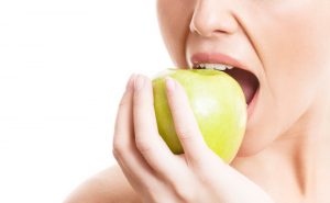 Young woman eating apple stock photo