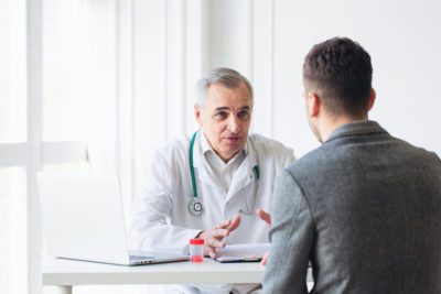 Patient Having Consultation With Doctor In Office stock photo