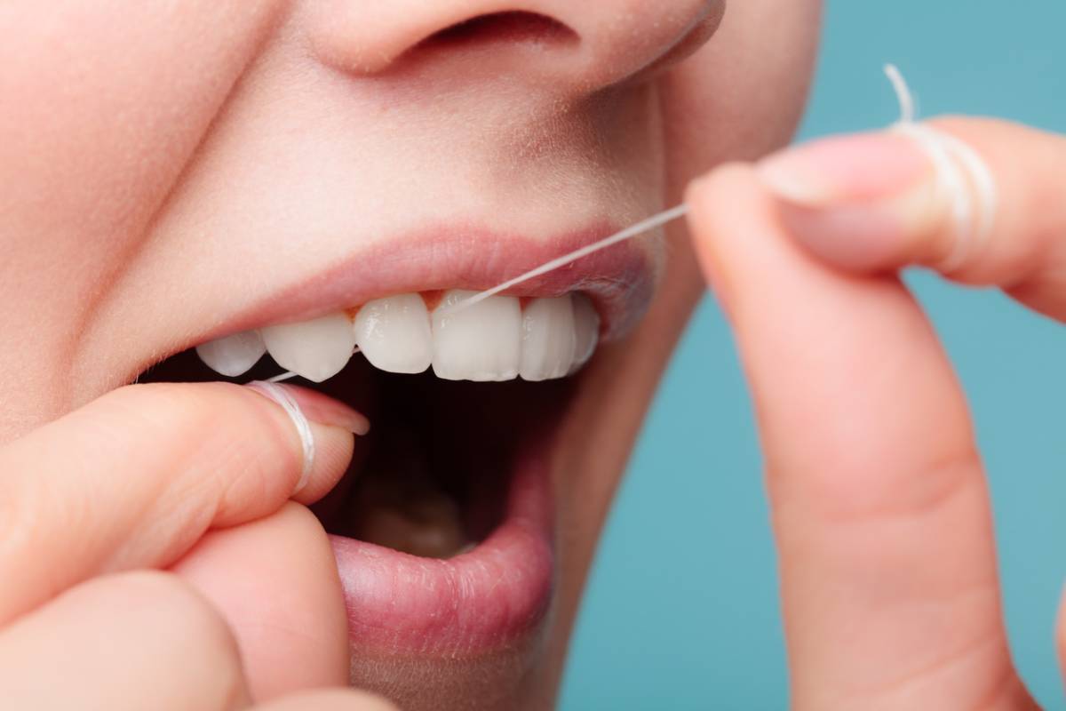 women use dental floss white healthy teeth stock photo